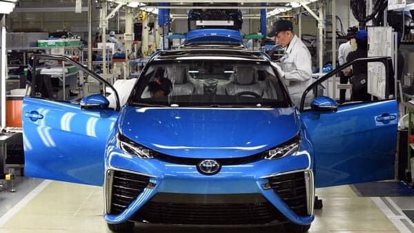 Employees of Toyota Motors check the FCV Mirai on its final assembly line at the Motomachi factory in Toyota city, Aichi prefecture. Toyota said it halted operations at 12 of its 14 factories in Japan due to a system glitch, but that it did not appear to be a cyberattack.