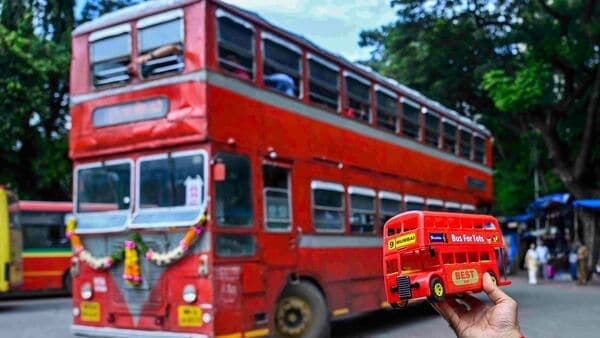 A man holds a miniature red non-AC double-decker bus of Brihanmumbai Electricity Supply and Transport (BEST), in Mumbai on Friday as the iconic buses, went off the streets after being an integral part of the city's public transport system for more than eight decades.