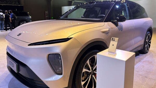 A Nio Phone is displayed next to a Nio ES8 SUV during a presentation in Shanghai, China.