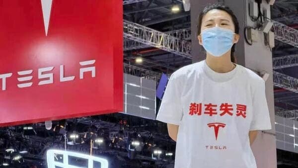 File photo of a protester alleging that Tesla EVs have brake-related issues, during the Shanghai Auto Show in 2021.