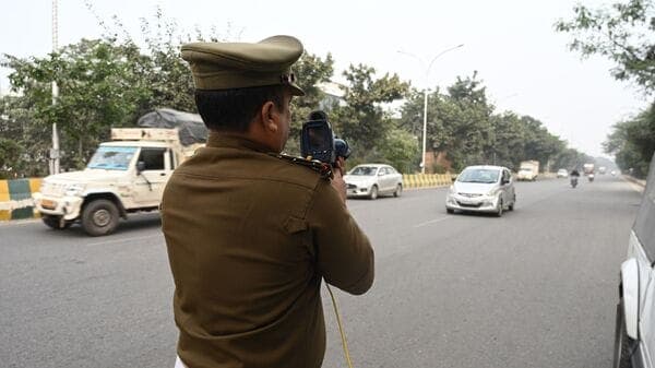 Noida Traffic Police personnel seen using speed guns to detect traffic violations. In November, the police issued more than 2.50 lakh challans to vehicle owners found flouting traffic rules. (Photo by Sunil Ghosh/Hindustan Times)
