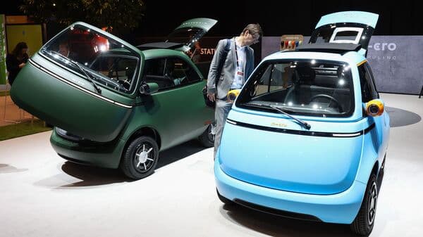An attendee looks at a Microlino EV on the opening day of the Geneva International Motor Show in Geneva, Switzerland.